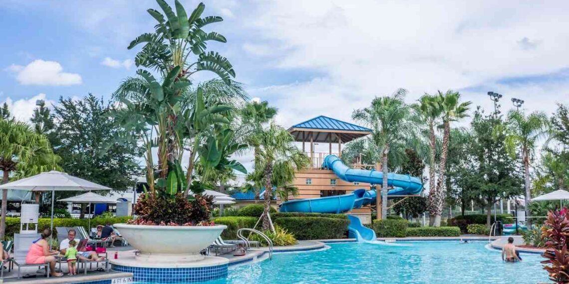 A water park at a family resort, surrounded by palm trees and a clear blue sky, inviting families to enjoy a fun experience.