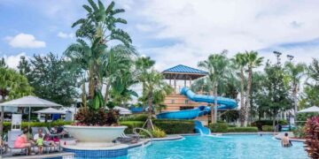 A water park at a family resort, surrounded by palm trees and a clear blue sky, inviting families to enjoy a fun experience.