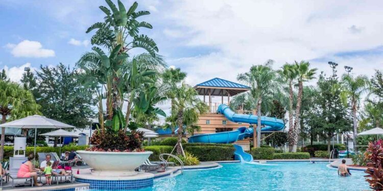 A water park at a family resort, surrounded by palm trees and a clear blue sky, inviting families to enjoy a fun experience.